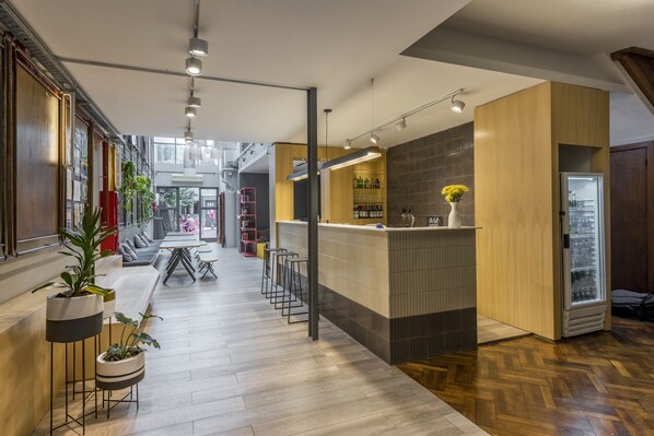 A modern interior with a reception area, bar, and seating area. - Puerto Limon Hostel (Buenos Aires)