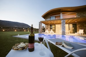 Una piscina al aire libre, sillones reclinables de piscina
