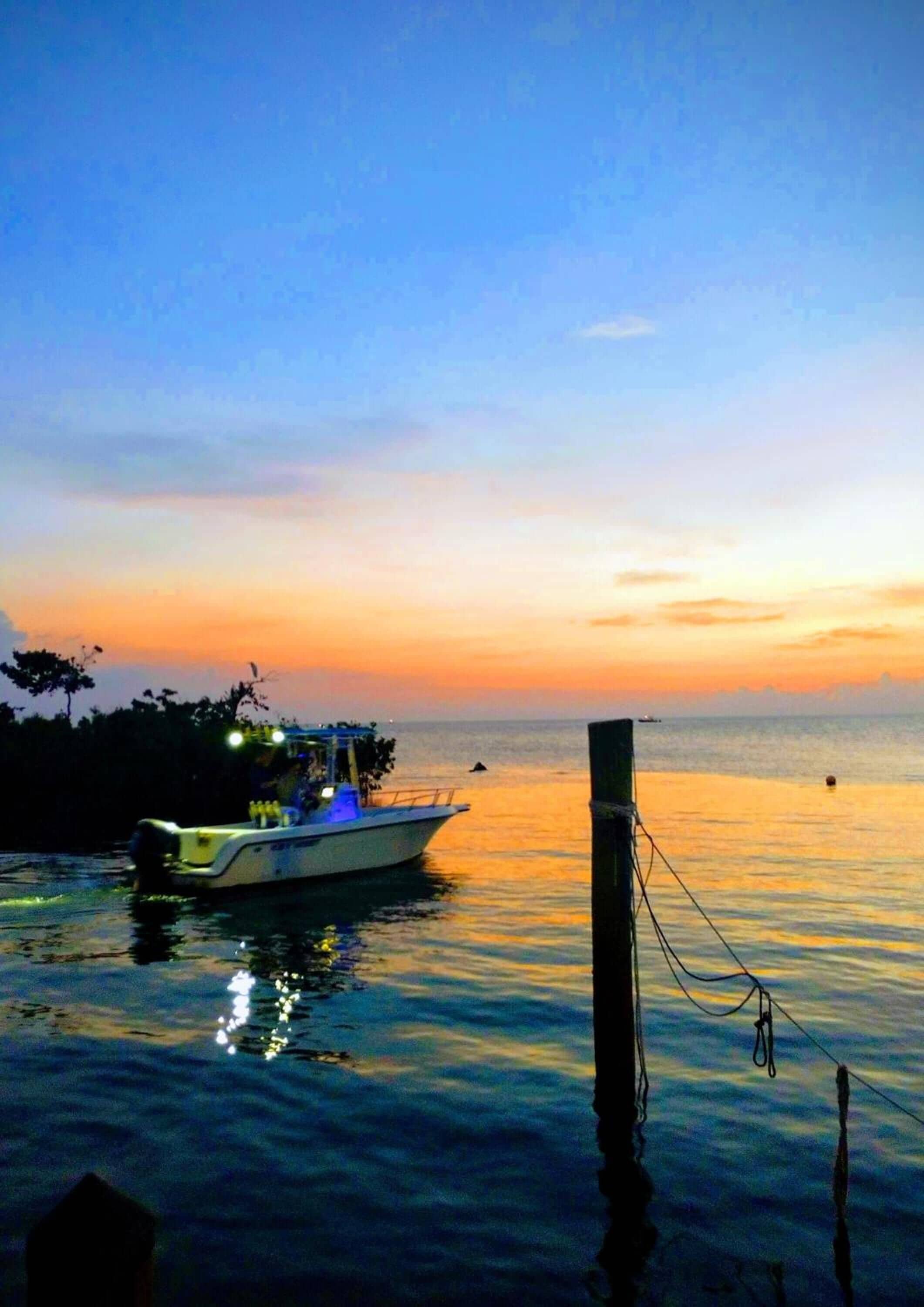 A boat docked at a pier during sunset.