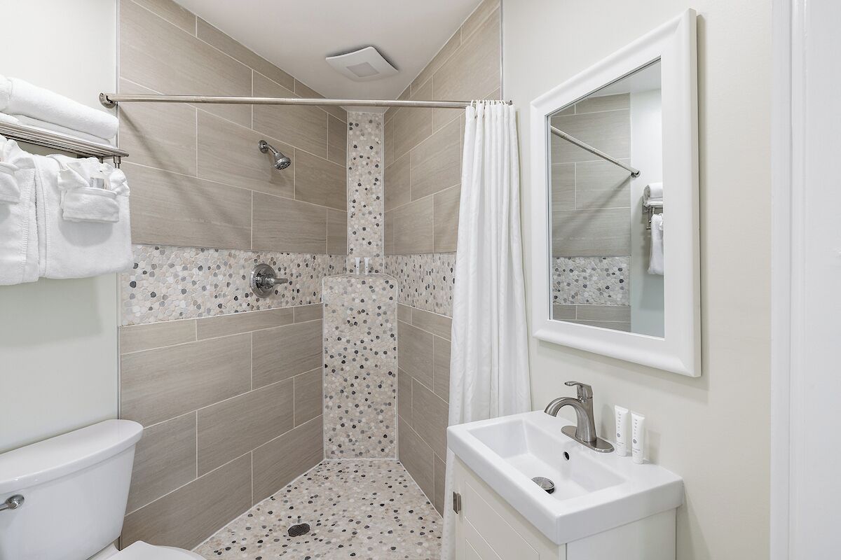 Une salle de bain moderne équipée d’une douche, de toilettes et d’un lavabo.