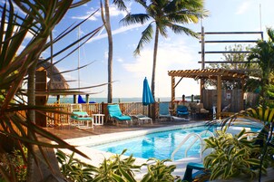 Una piscina al aire libre, sillones reclinables de piscina