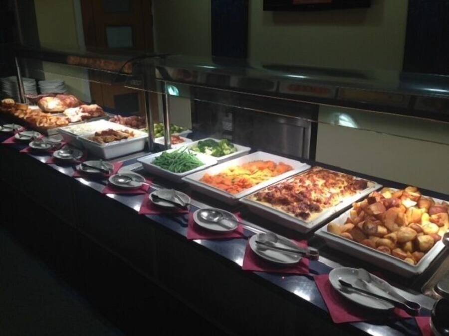 A buffet with various food items including salads, meats, and baked goods.