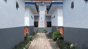 A corridor with a tiled roof, potted plants, and a sign reading "SURIA". - Suria Beach Resort (Pangkor Island)