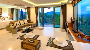 A modern hotel room with a balcony, a dining area, and a sofa. - At The Tree Phuket (Rawai)