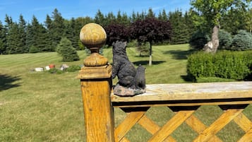 Geländer aus Holz mit einer verzierten Balustrade und einer kleinen Bärenfigur.