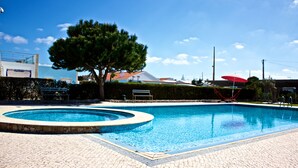 A swimming pool with a circular edge, a bench, and a hammock. - Neptuno (Peniche)