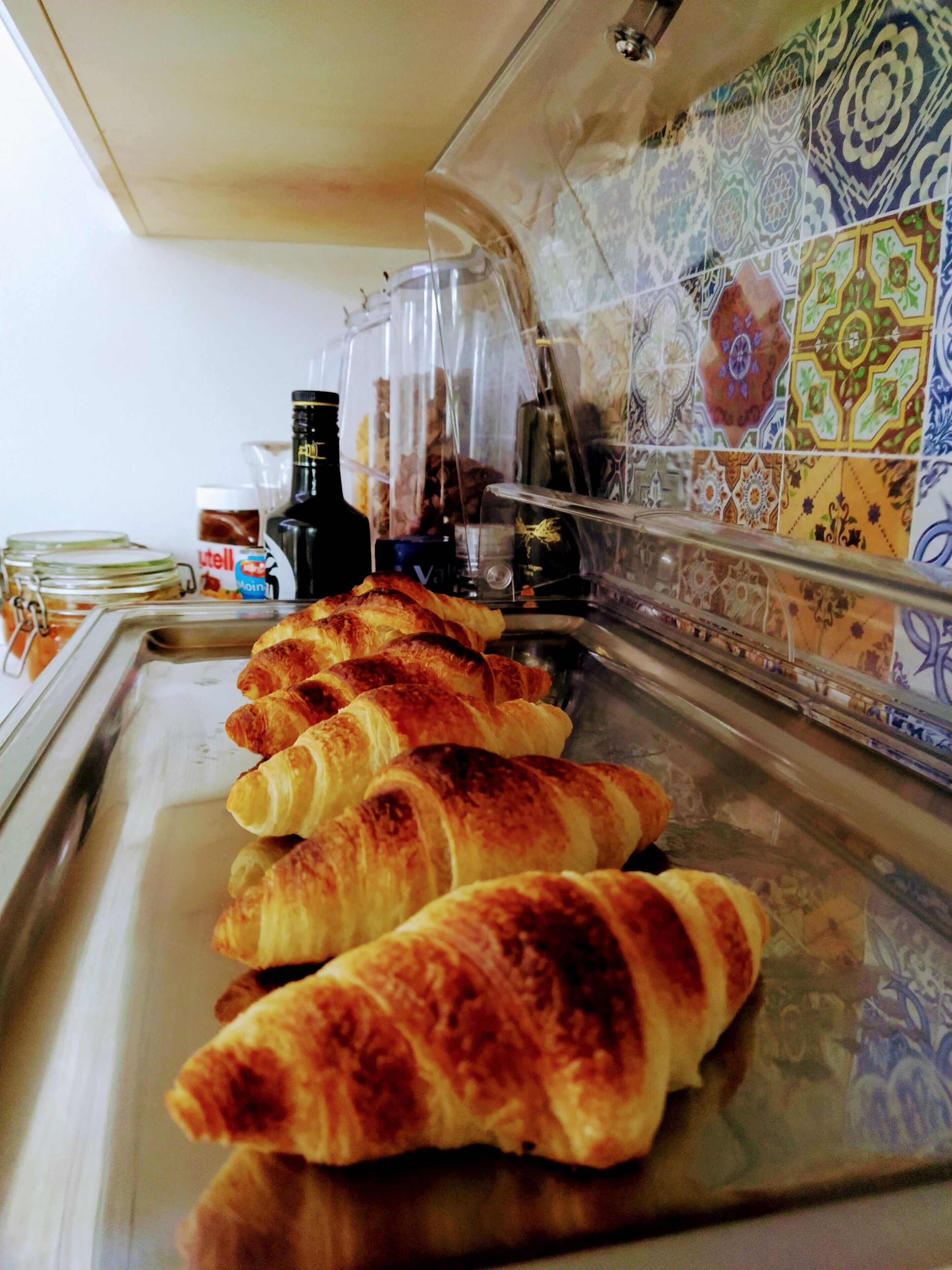 Leipomon vitriini, jossa on tuoreita, vastapaistettuja croissantteja ja erilaisia lisukkeita.