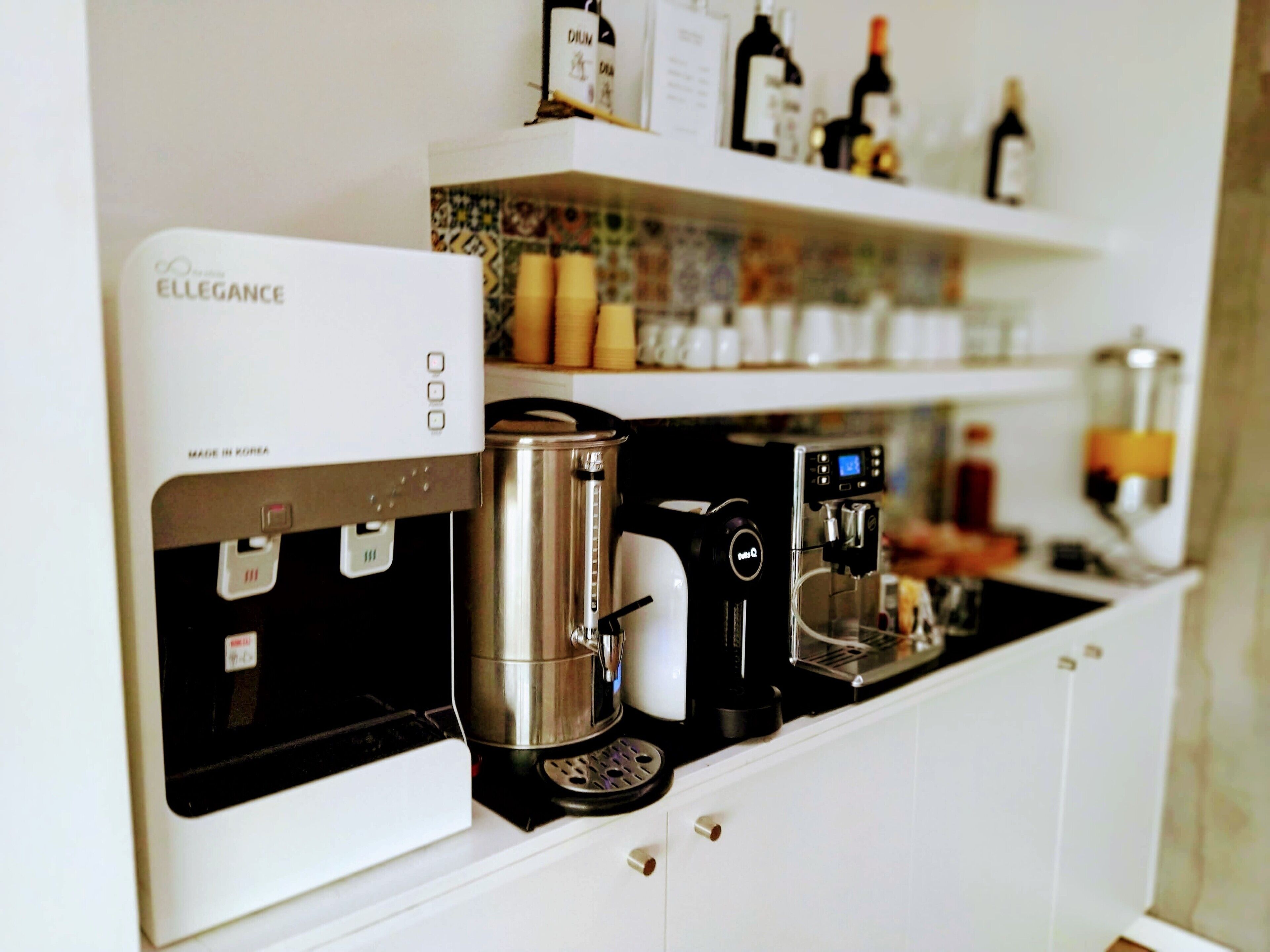 En kaffemaskin och en vattenkokare står på en köksbänk.
