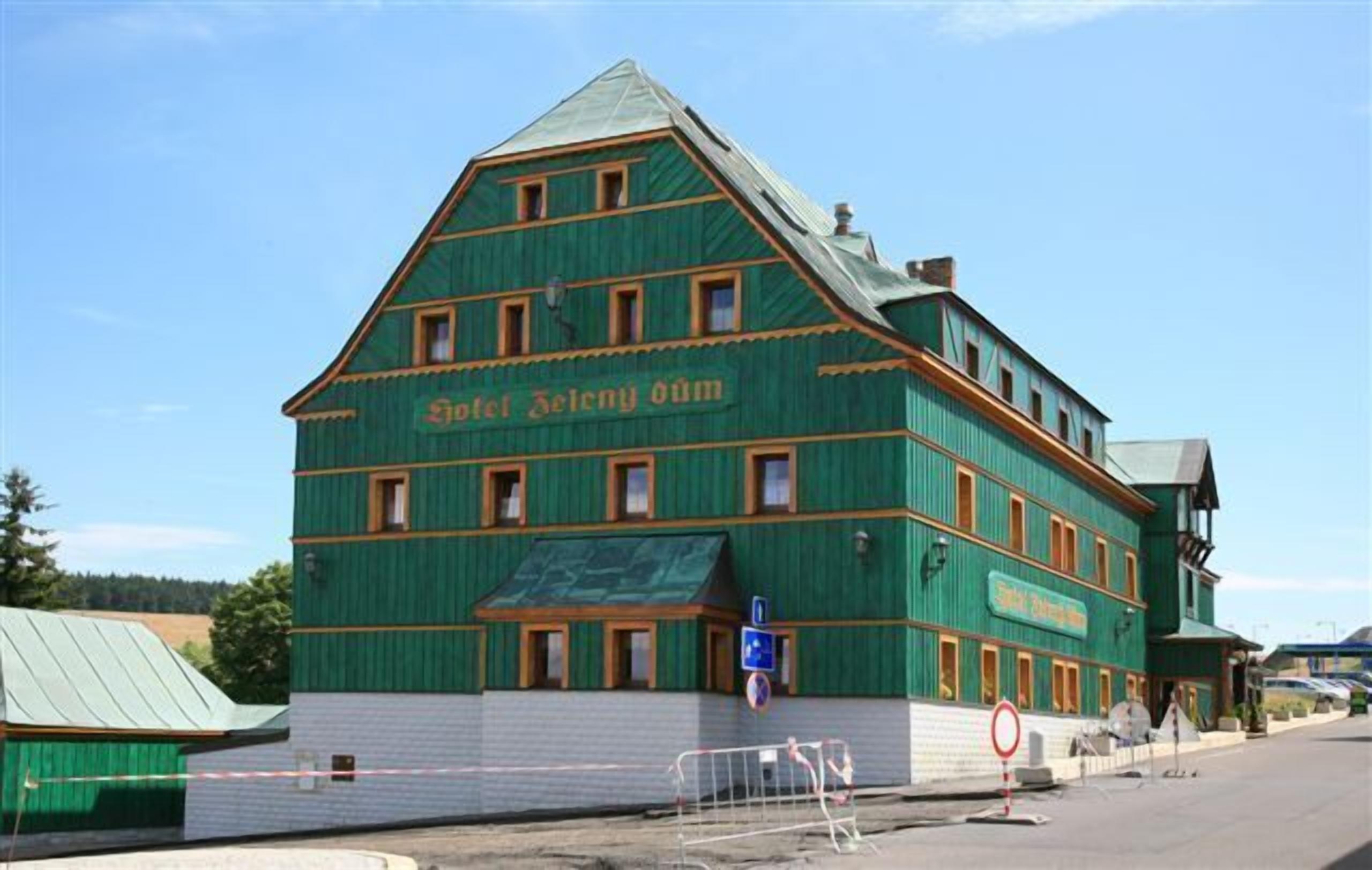 Ein großes, mehrstöckiges Gebäude mit grüner Fassade und einem Schild mit der Aufschrift 'Hotel Zelenskyy'.