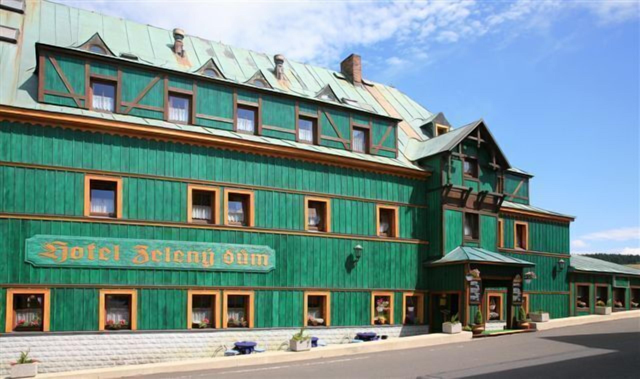 Un edificio grande de madera verde con un letrero que dice "Hotel Selge dam".