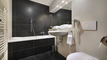 Un baño moderno con bañera, lavamanos e inodoro.