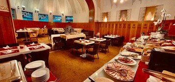 Un restaurante con varias mesas, sillas y una variedad de alimentos a la vista.