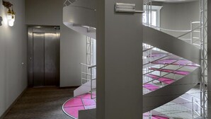 A modern interior with a spiral staircase, a door, and a light fixture.