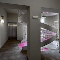 Un interior moderno con una escalera de caracol, una puerta y una lámpara.