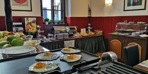 Disposición de bufé con diferentes opciones de comida y una parrilla para huevos.