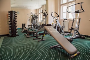 A gym with various exercise equipment including treadmills, stationary bikes, and weight machines.