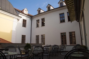 Un patio con mobiliario exterior y varias ventanas.