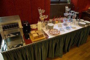 Una mesa de buffet con diversos alimentos, utensilios y aderezos.