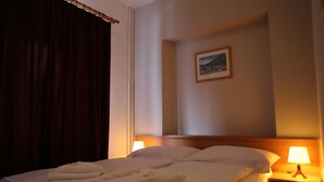 A hotel room with a bed, two bedside lamps, a picture on the wall, and a window with curtains. - Hotel Harrachov Inn (Harrachov)