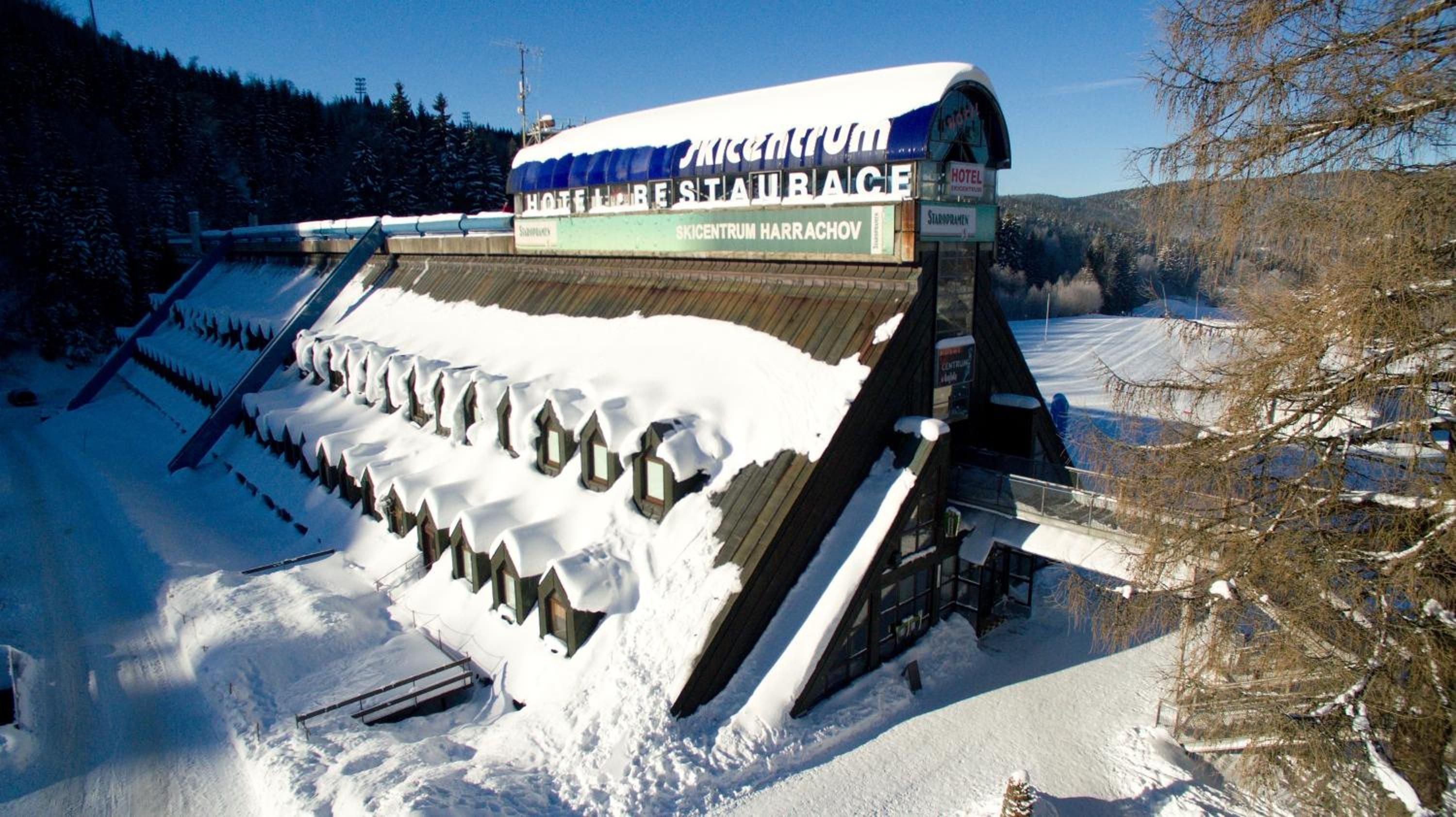 A hotel with a snow-covered roof and a sign indicating it is a restaurant.