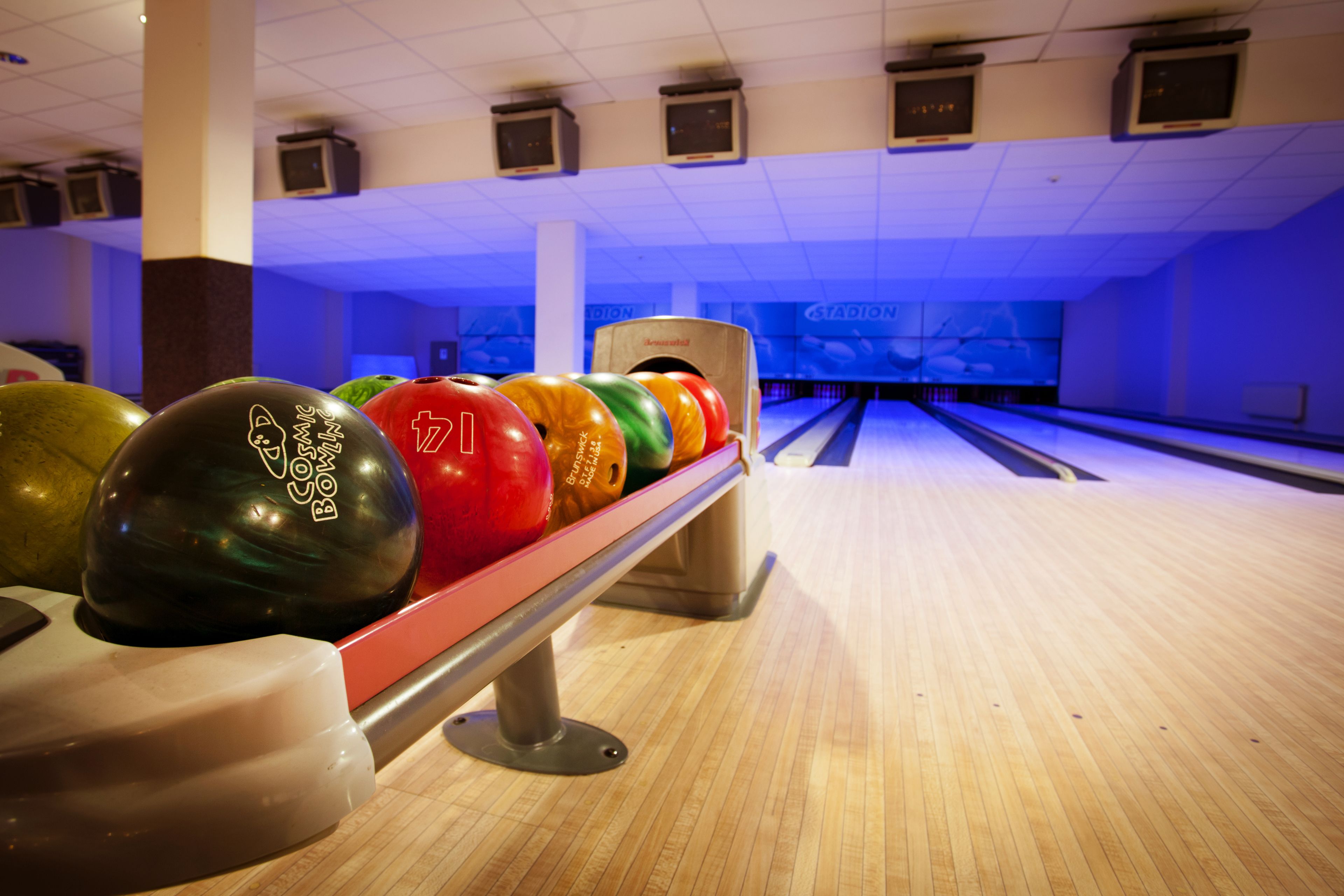 A bowling alley with lanes, a bowling ball rack, and a bowling ball with the number 7.