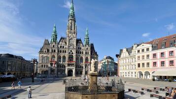 Un bâtiment historique doté d’un imposant clocher et d’une fontaine centrale.