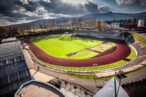 A stadium with a running track, a football field, and spectator stands. - Hotel Arena (Liberec)