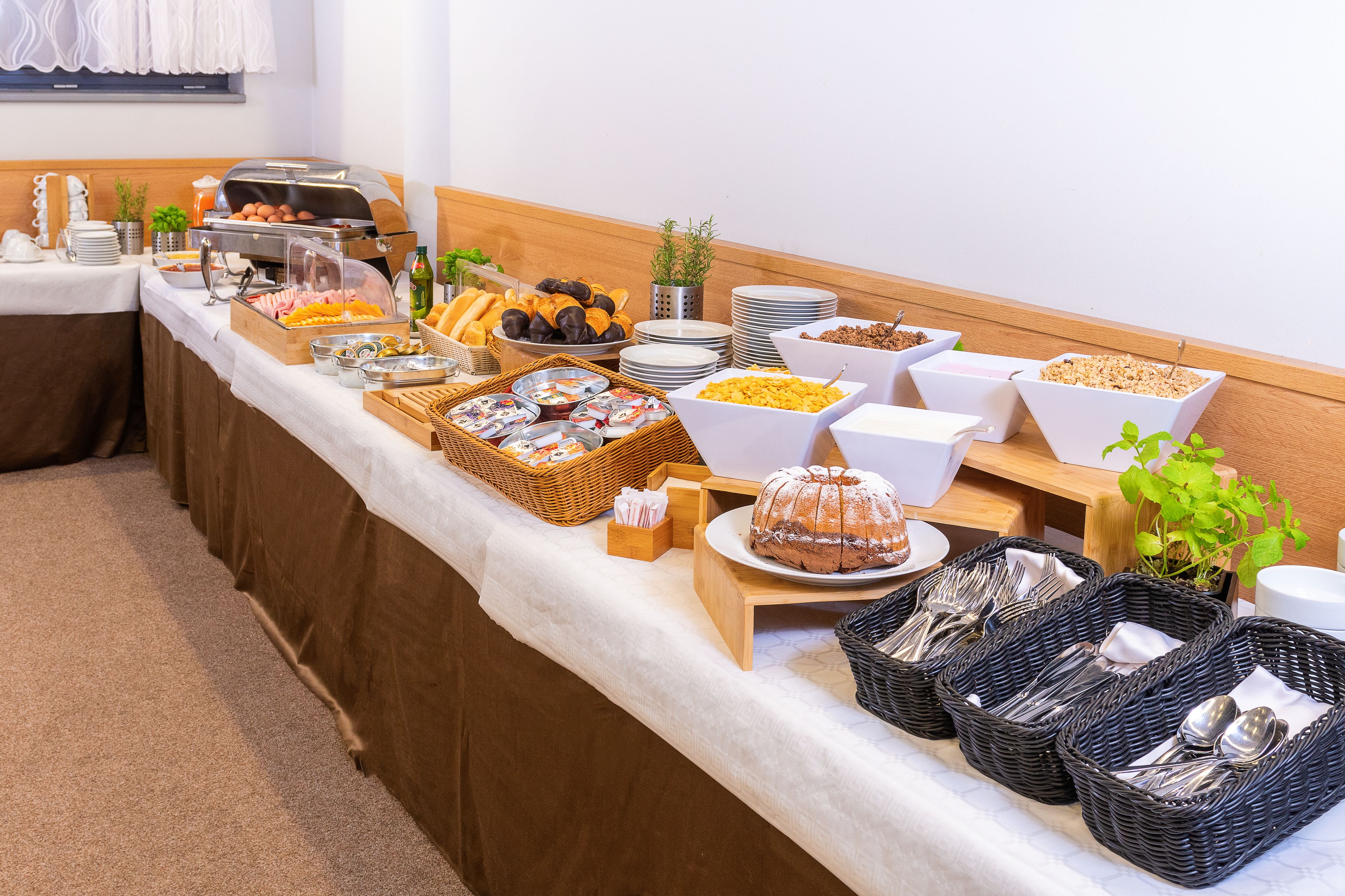 A buffet with various food items and utensils.