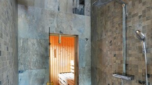 Un baño moderno con ducha, un banco de madera y un revestimiento de azulejos.