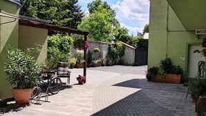 Un patio con recepción, plantas en macetas y una bicicleta.