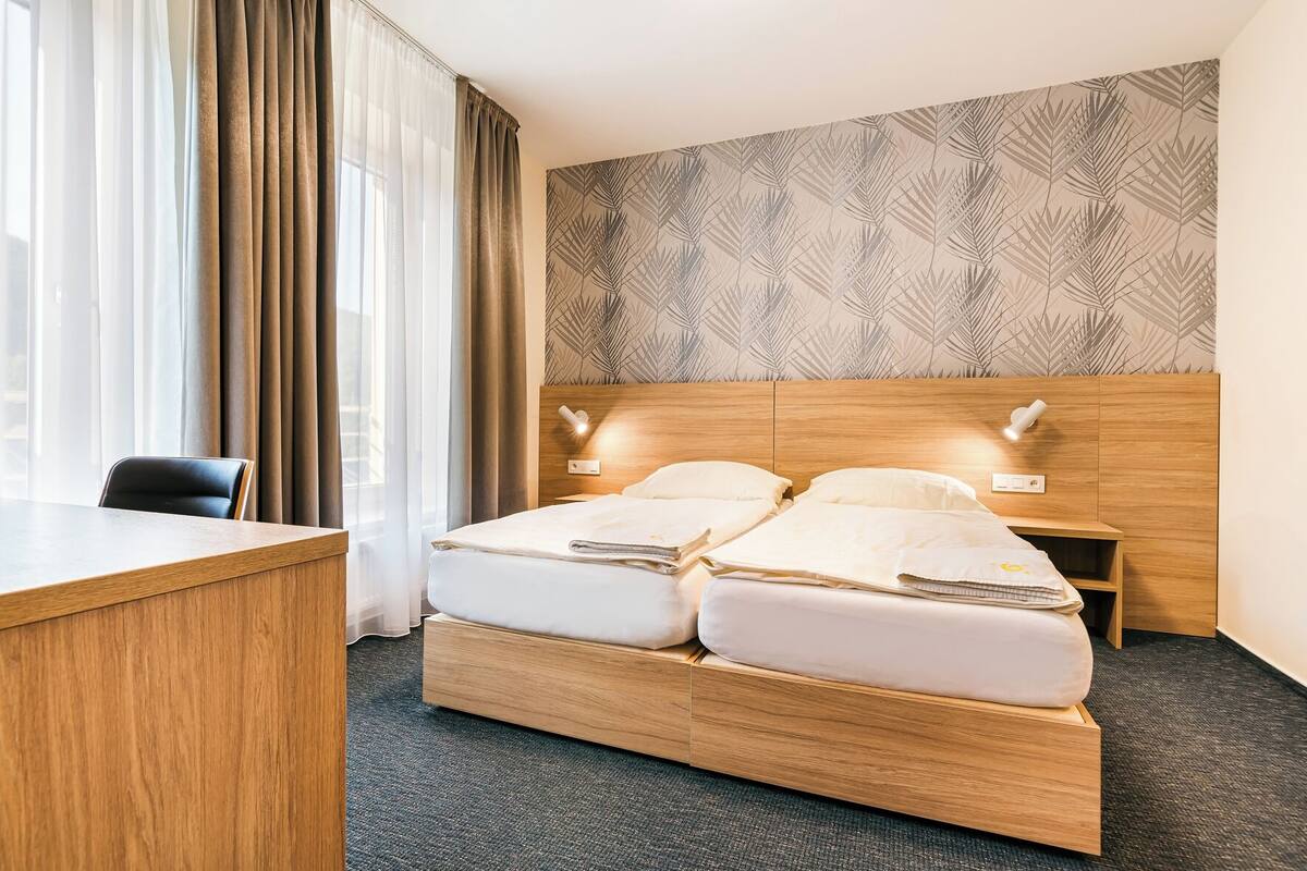 Ein Hotelzimmer mit einem Holzbett, einem Schreibtisch und einem Nachttisch.