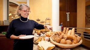 A buffet setup with various food items including bread, pastries, and meats. - Hotel Binggl (Mauterndorf)