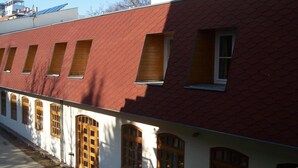 A row of white buildings with red roofs and wooden windows. - Amphone (Brno)