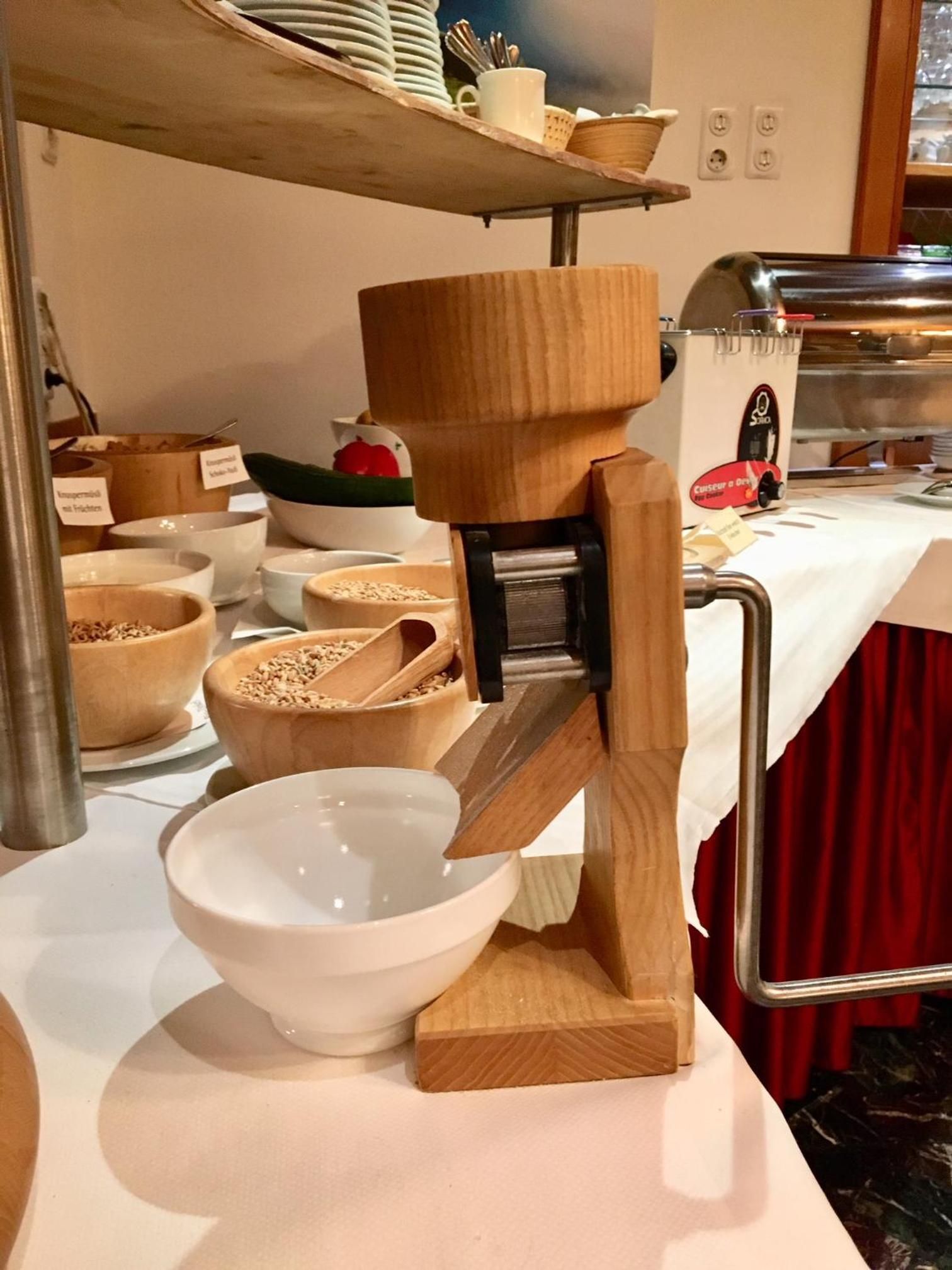 Een keukenhoek met een houten keukenmachine, kommen en een roestvrijstalen apparaat.
