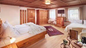Quarto com painéis de madeira, uma cama, uma escrivaninha, uma televisão e um guarda-roupa.