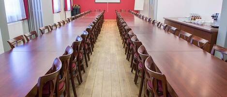 A conference room with a long table and chairs, a projector screen, and a whiteboard.