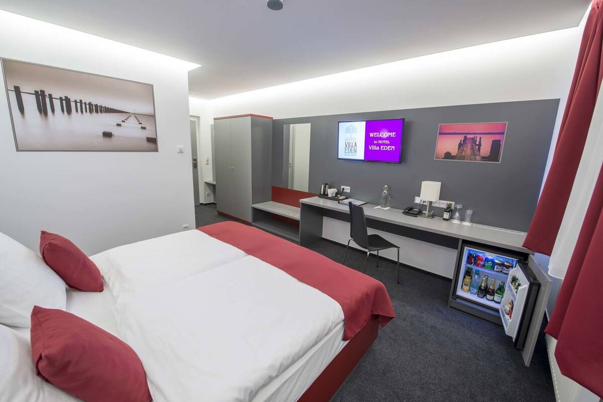 Une chambre d’hôtel avec un lit, un bureau et un mini-bar.