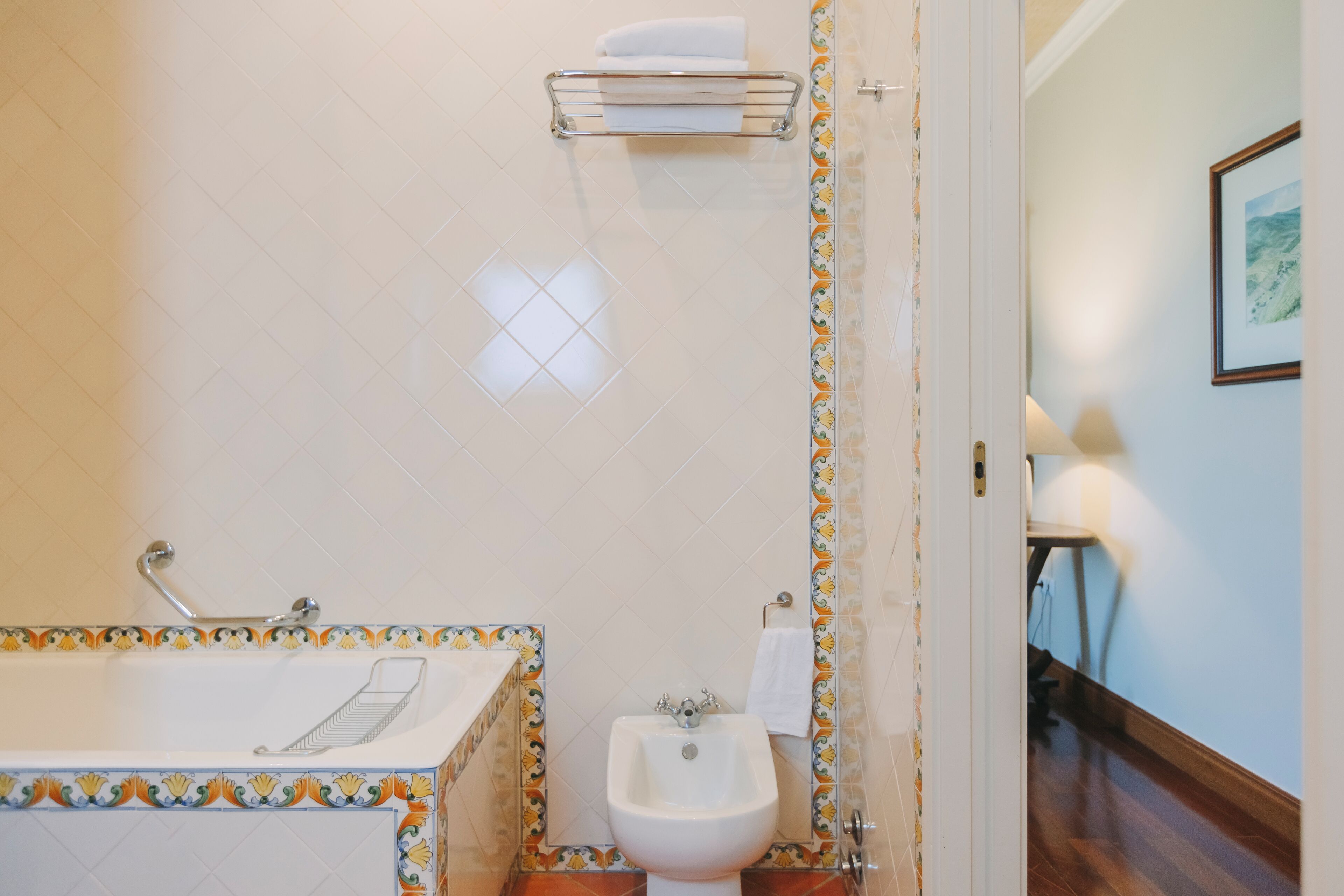 A bathroom with a bathtub, a bidet, and a towel rack.