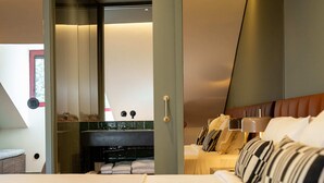 A modern hotel room with a large bed, a bathroom with a mirror, and a view of the sky. - Santo Thyrso Hotel (Santo Tirso)