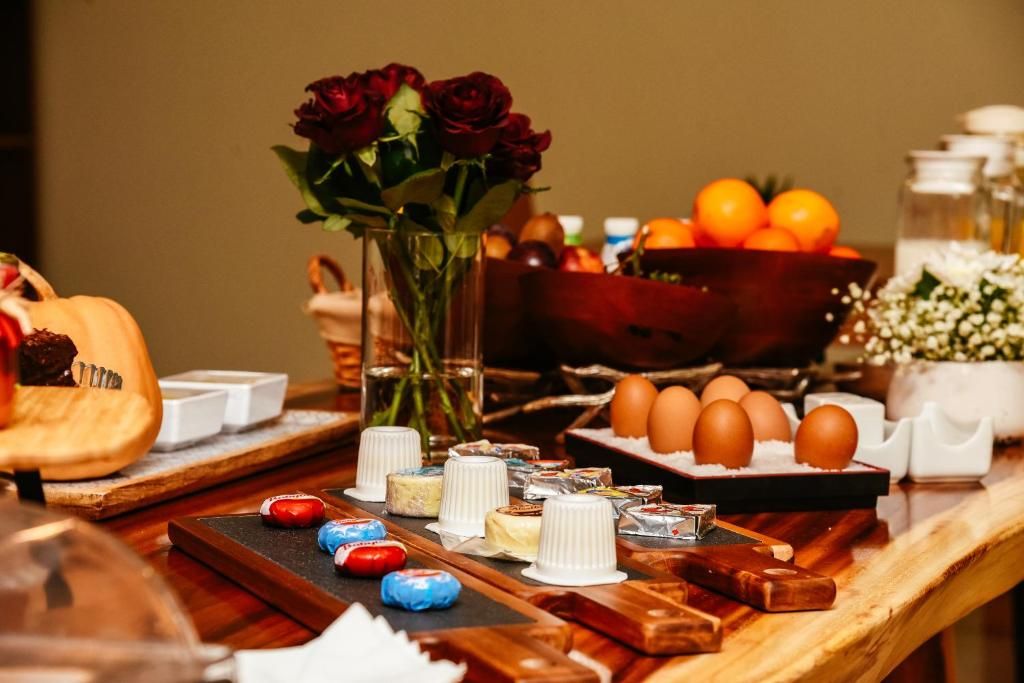 Ein reichhaltiges Buffet mit verschiedenen Speisen, einer Rosenvase und einer Schüssel Orangen.