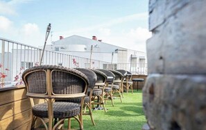 Outdoor wicker chairs arranged on a grassy area with a building in the background. - Santo Thyrso Hotel (Santo Tirso)