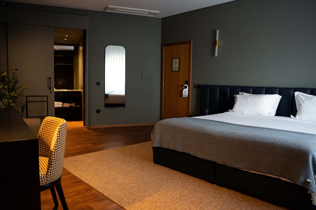 Een hotelkamer met een bed, een bureau en een stoel.