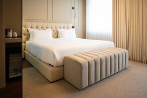 A hotel room with a large bed, a bedside table with a lamp, and a window with curtains. - Santo Thyrso Hotel (Santo Tirso)