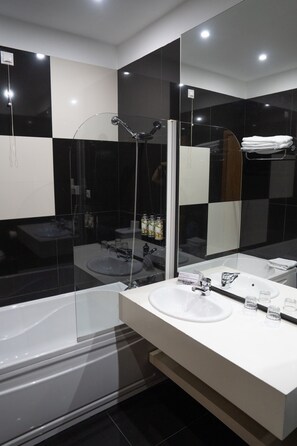 A modern bathroom with a glass-enclosed shower, a white sink, and a large mirror. - Santo Thyrso Hotel (Santo Tirso)