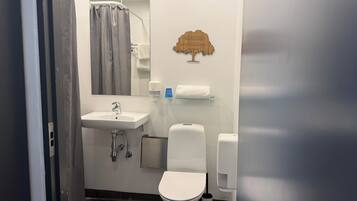 Un bagno piccolo con il water, un lavandino e una doccia.
