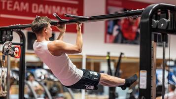 Una persona haciendo un ejercicio de dominada en una barra de gimnasio.