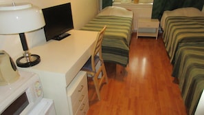 A hotel room with a desk, television, and two beds. - Nepi Hotell (Tallinn)