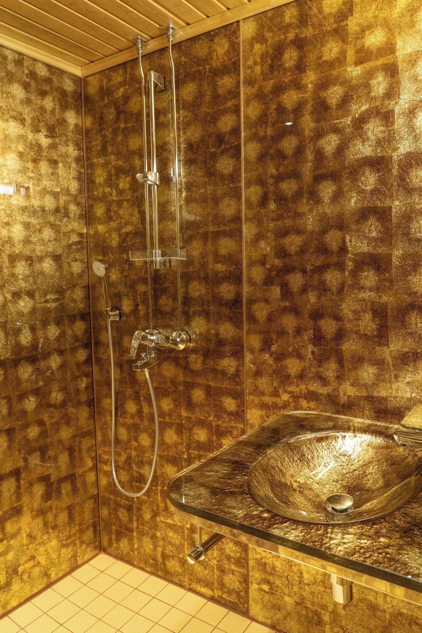 Une salle de bain dotée d’une douche à parois de verre, d’un lavabo avec un receveur brillant et de murs carrelés.
