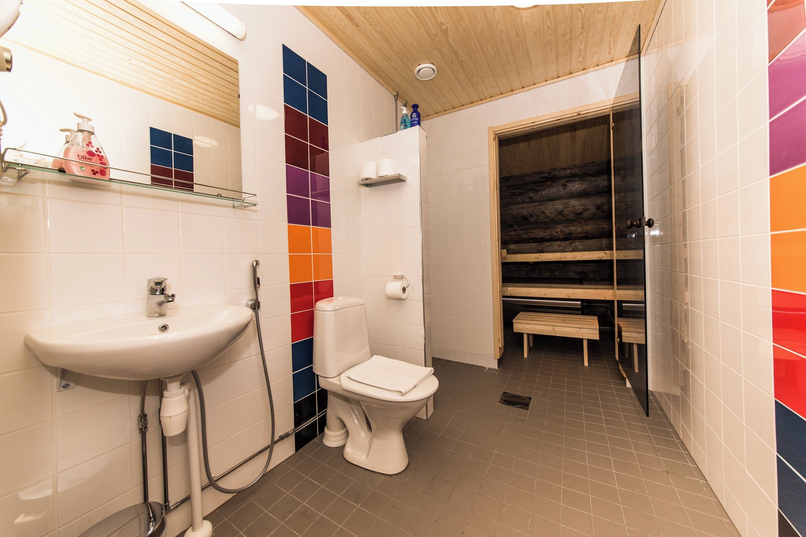 A bathroom with a sink, toilet, and bench.