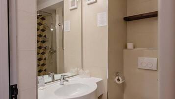 Ein Badezimmer mit einem Doppelwaschbecken, einer Toilette, einem Spiegel und einer Dusche.
